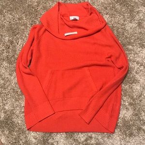 Salmon colored sweater with hoodie pocket.